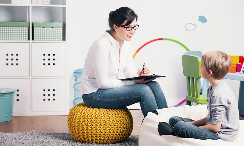 Woman taking notes while speaking to young boy