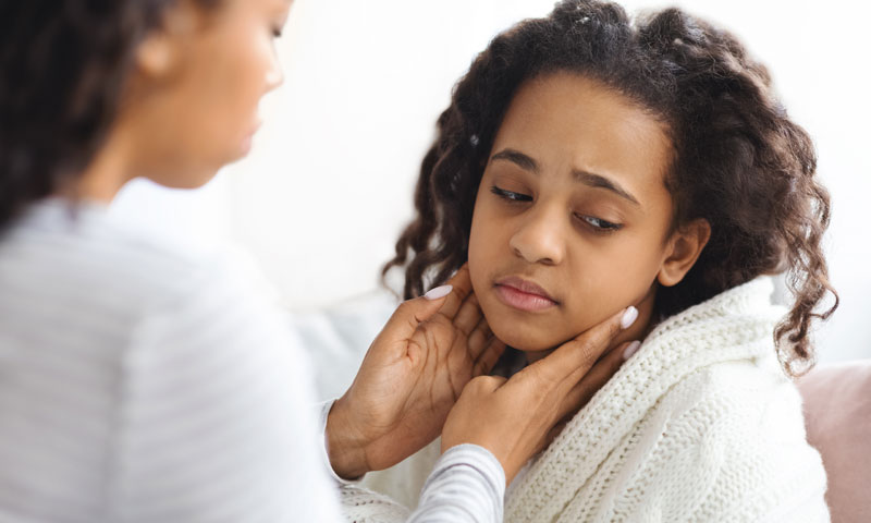 Young girl getting checked out by her mom while being sick